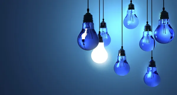 Idea concept, Hanging light bulbs with glowing one isolated on dark blue background